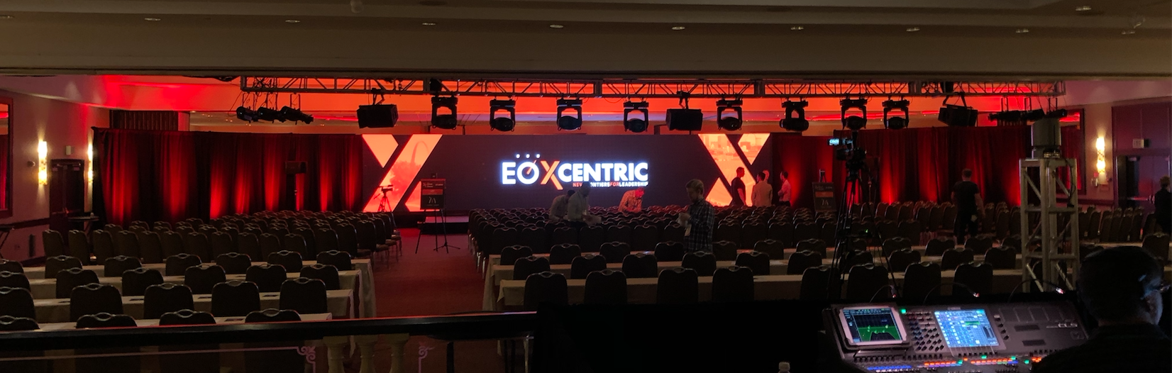 Corporate Conference Design in a ballroom with red lighting and an led video wall display