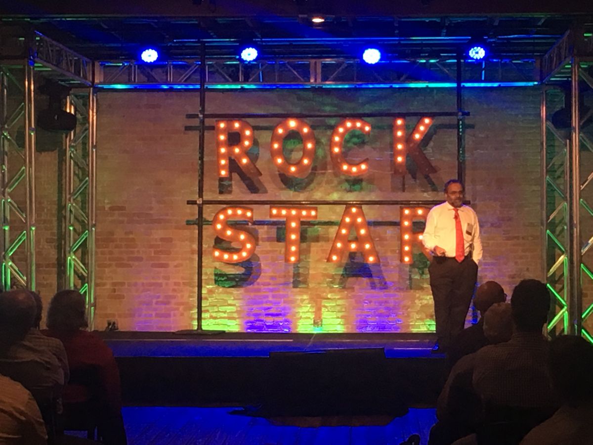 Man on stage with Rock Star signage 