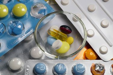 Image of medications inside a bowl surrounded by medications inside blister packets Medication Services