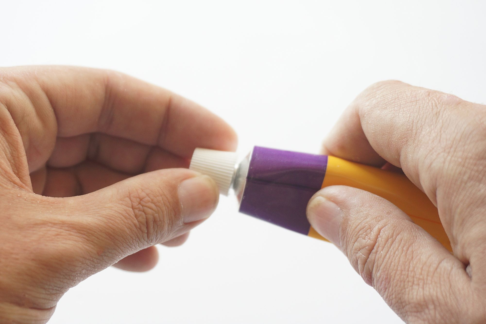 Patient squeezes out of aluminum tubes ointment with medicinal substance on finger. Photo of use of drug in form of ointments for