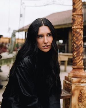 woman standing outside with long brunette hair facing camera woman outside with long dark brown hair
