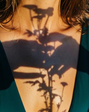 image of a shadow of flowers on woman's neck moody shadow photo
