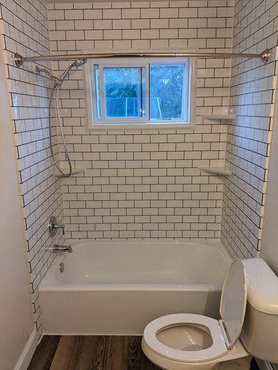 Thin White Subway Tile Shower with Black Grout